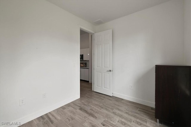 409 Columbus Blvd S, Lehigh Acres, FL 33974 - empty room featuring baseboards and light wood-type flooring