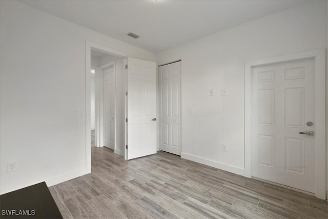 409 Columbus Blvd S, Lehigh Acres, FL 33974 - unfurnished bedroom featuring light wood-type flooring, baseboards, and a closet