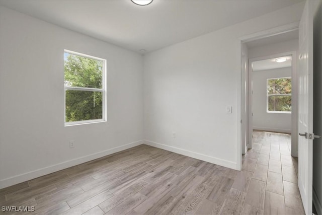 409 Columbus Blvd S, Lehigh Acres, FL 33974 - unfurnished room featuring healthy amount of natural light, light wood-type flooring, and baseboards