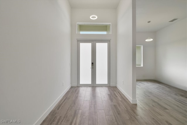 409 Columbus Blvd S, Lehigh Acres, FL 33974 - foyer entrance featuring wood finished floors, baseboards, a towering ceiling, and french doors
