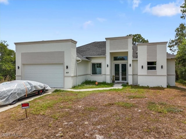 409 Columbus Blvd S, Lehigh Acres, FL 33974 - contemporary house with french doors, stucco siding, a garage, roof with shingles, and driveway
