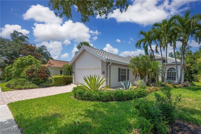 3803 Valentia Way, Naples, FL 34119 - view of front of house featuring an attached garage, a front yard, driveway, stucco siding, and a tile roof