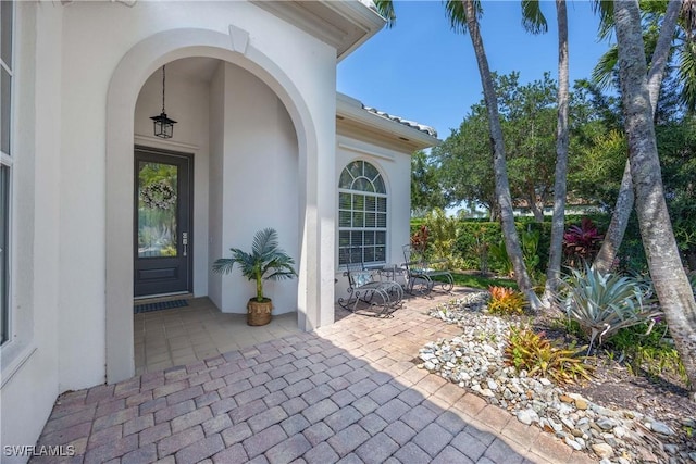 3803 Valentia Way, Naples, FL 34119 - doorway to property with stucco siding and a patio