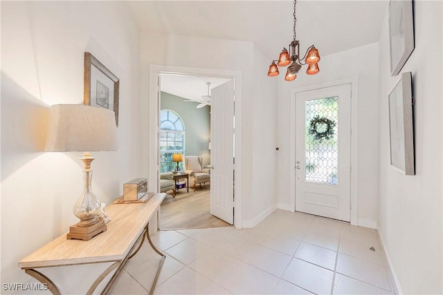 3803 Valentia Way, Naples, FL 34119 - foyer with a chandelier, baseboards, light tile patterned flooring, and ceiling fan