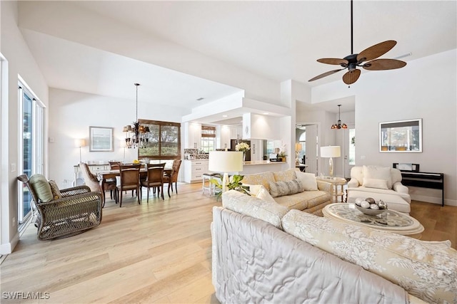 3803 Valentia Way, Naples, FL 34119 - living room featuring light wood-style flooring, a ceiling fan, healthy amount of natural light, and a chandelier