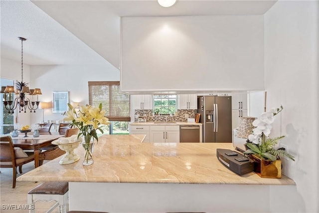 3803 Valentia Way, Naples, FL 34119 - kitchen with stainless steel appliances, a sink, white cabinetry, light stone countertops, and decorative backsplash
