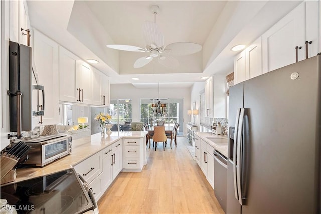 3803 Valentia Way, Naples, FL 34119 - kitchen with stainless steel appliances, white cabinets, recessed lighting, light wood-style flooring, and ceiling fan