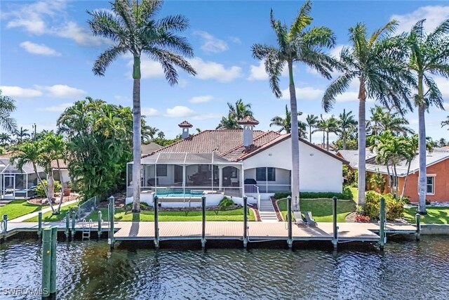dock featuring a water view, glass enclosure, an outdoor pool, and boat lift