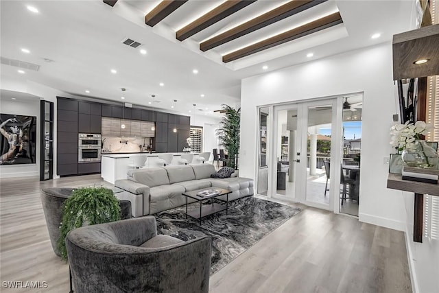 living room with light wood-type flooring and recessed lighting