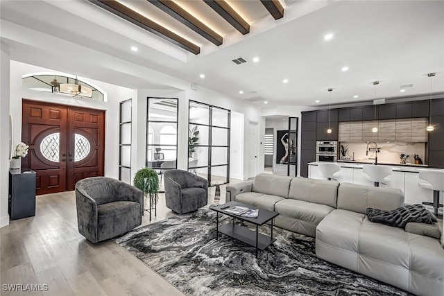 living area featuring recessed lighting, light wood-type flooring, and beamed ceiling