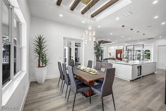 dining room with light wood finished floors, recessed lighting, baseboards, and a chandelier