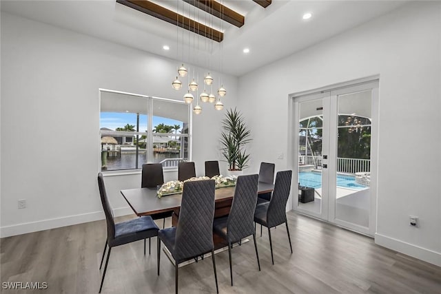 dining room featuring healthy amount of natural light, wood finished floors, recessed lighting, and baseboards