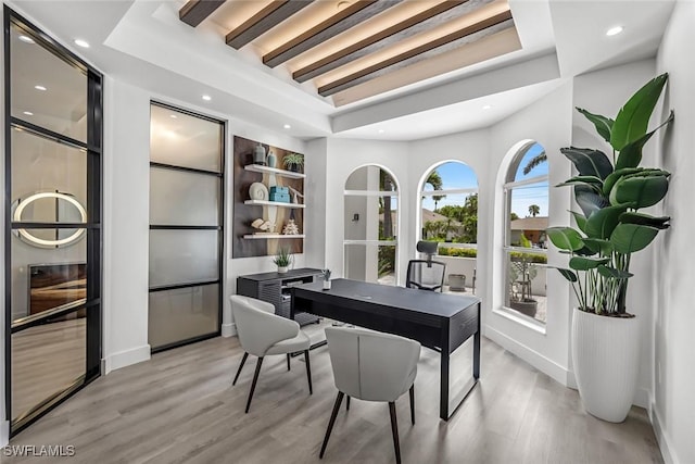 office area with light wood-type flooring, recessed lighting, a tray ceiling, and baseboards