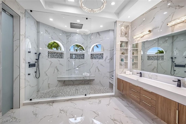 bathroom featuring a marble finish shower, marble tiled floors, recessed lighting, double vanity, and a tray ceiling
