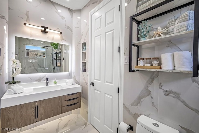full bathroom with toilet, marble tiled flooring, a marble finish shower, and vanity
