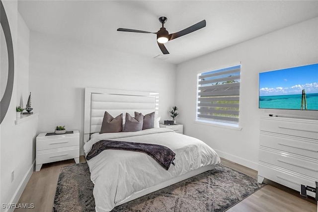 bedroom featuring wood finished floors, baseboards, and a ceiling fan