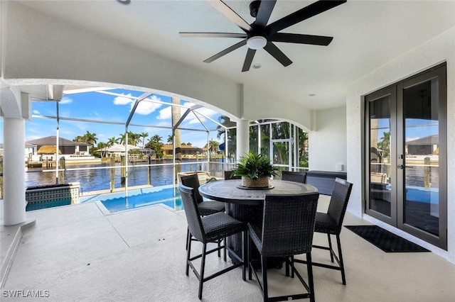 swimming pool featuring french doors, a water view, a patio area, and ceiling fan