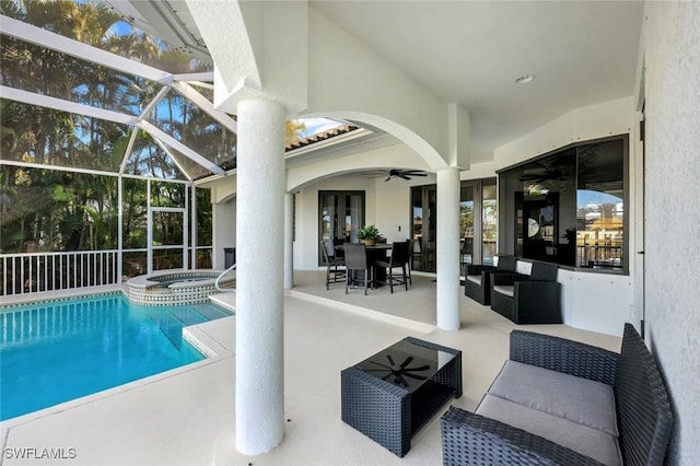 view of pool with ceiling fan, outdoor lounge area, a patio, a pool with connected hot tub, and glass enclosure