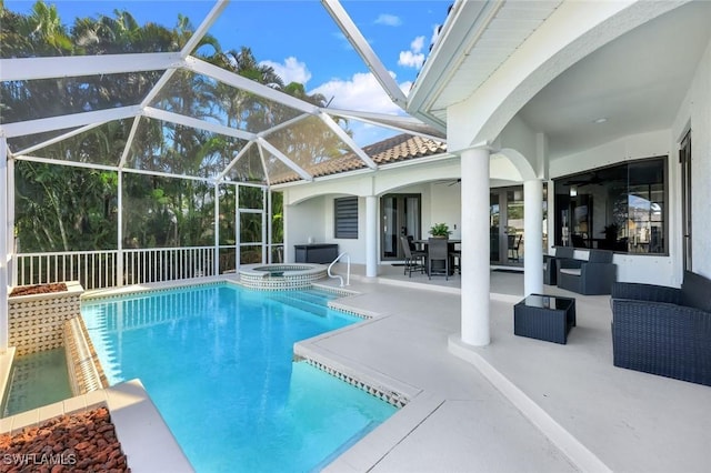 view of pool featuring a patio area, a pool with connected hot tub, glass enclosure, and outdoor lounge area