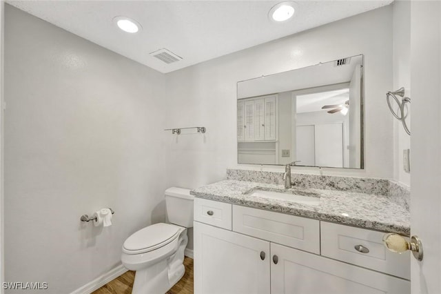 7400 College Pkwy Unit 5A, Fort Myers, FL 33907 - half bathroom with toilet, wood finished floors, baseboards, vanity, and ceiling fan
