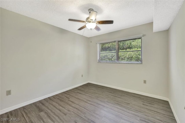 7400 College Pkwy Unit 5A, Fort Myers, FL 33907 - empty room featuring wood finished floors, ceiling fan, baseboards, and a textured ceiling