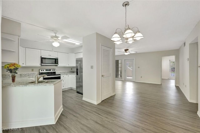 7400 College Pkwy Unit 5A, Fort Myers, FL 33907 - kitchen with appliances with stainless steel finishes, a ceiling fan, open shelves, a chandelier, and open floor plan