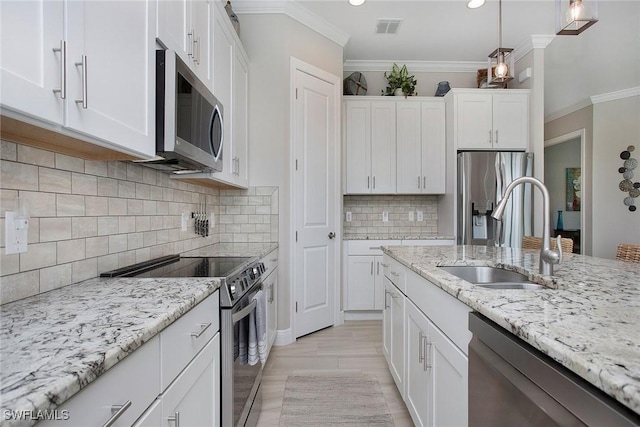 1421 Lucena Ln S, Naples, FL 34113 - kitchen with stainless steel appliances, a sink, white cabinetry, crown molding, and pendant lighting