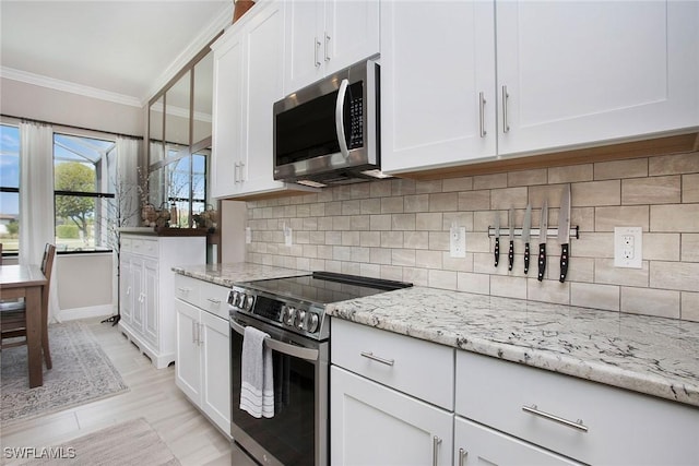 1421 Lucena Ln S, Naples, FL 34113 - kitchen with appliances with stainless steel finishes, crown molding, white cabinets, and light stone countertops