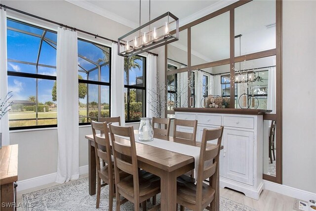 1421 Lucena Ln S, Naples, FL 34113 - dining space featuring baseboards, a chandelier, crown molding, and plenty of natural light