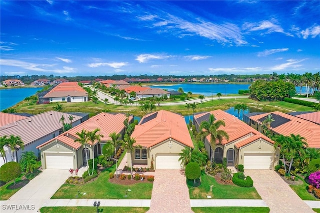 1421 Lucena Ln S, Naples, FL 34113 - view of front facade with driveway, a water view, stucco siding, a residential view, and a garage