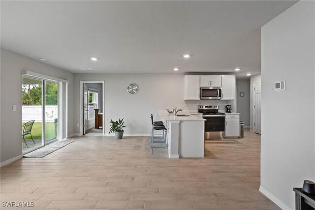 3021 June Cir, Labelle, FL 33935 - kitchen with appliances with stainless steel finishes, baseboards, white cabinetry, a sink, and light countertops