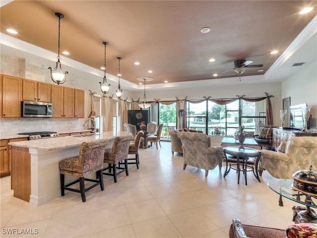 9340 Woodhurst Dr, Naples, FL 34120 - kitchen featuring a sink, a tray ceiling, visible vents, stainless steel microwave, and range