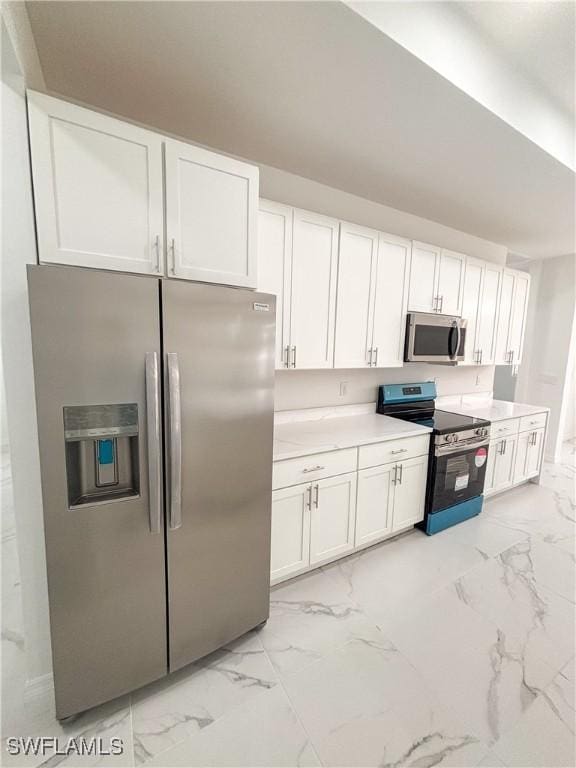 3210 30th St SW, Lehigh Acres, FL 33976 - kitchen featuring light countertops, white cabinets, marble finish floor, and appliances with stainless steel finishes