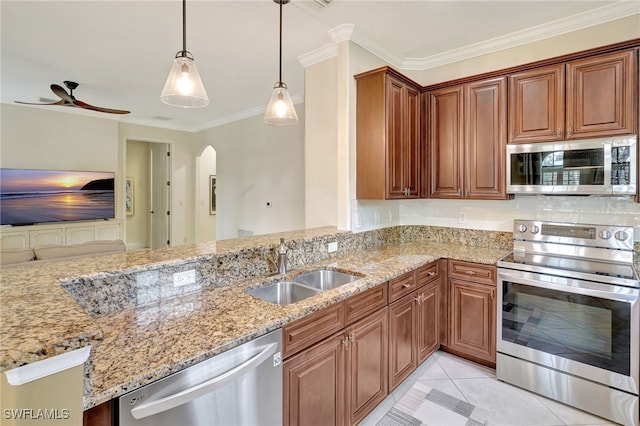 kitchen with appliances with stainless steel finishes, a sink, arched walkways, light stone countertops, and crown molding