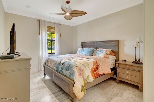 bedroom with light wood finished floors, ceiling fan, crown molding, and baseboards