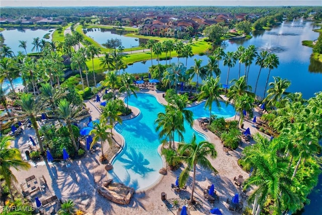 drone / aerial view of a nearby body of water and a pool area