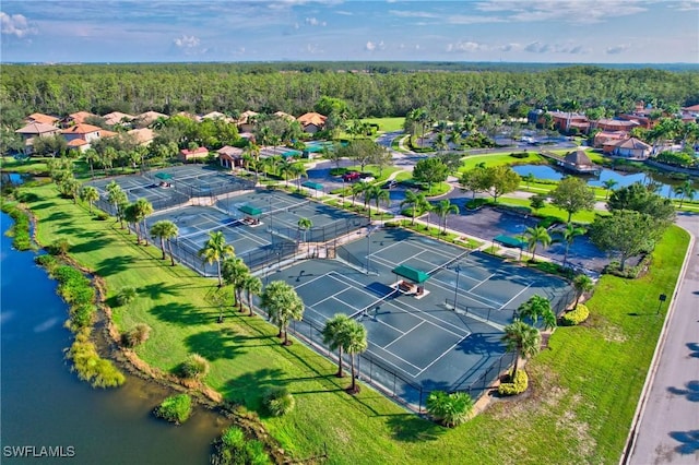 drone / aerial view of a nearby body of water and a forest
