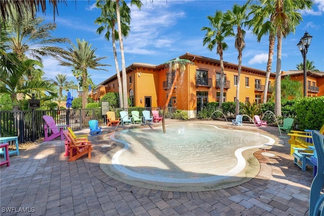 community pool featuring fence and a patio
