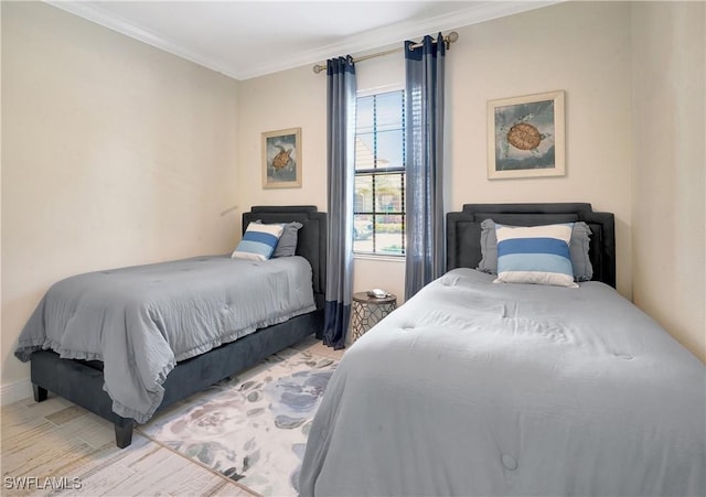 bedroom with ornamental molding and light wood-style flooring