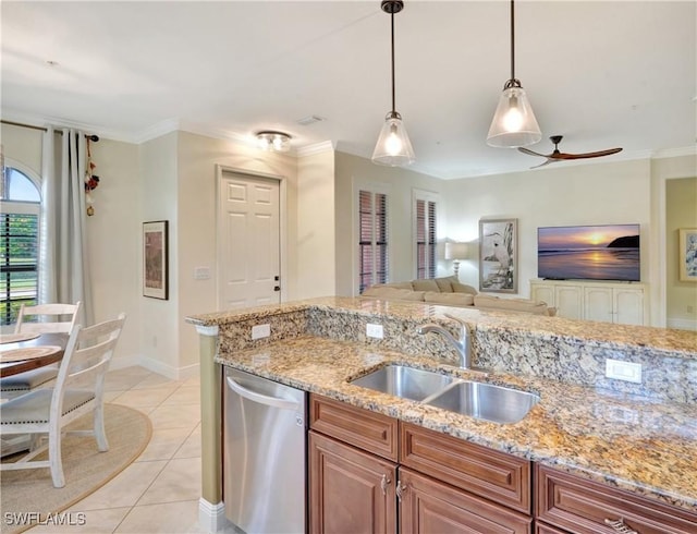 kitchen featuring dishwasher, a sink, hanging light fixtures, light tile patterned flooring, and light stone counters