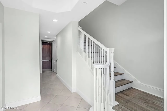 stairway featuring recessed lighting, baseboards, and tile patterned flooring