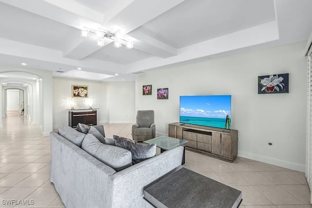 living area featuring light tile patterned floors, arched walkways, a tray ceiling, baseboards, and recessed lighting