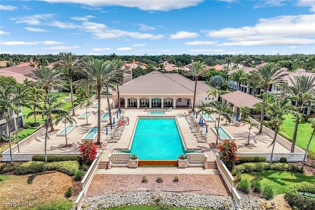 community pool with a patio, a community hot tub, and fence