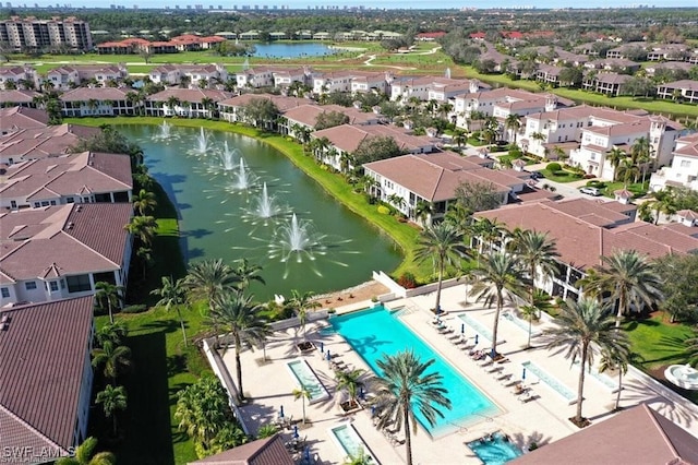 drone / aerial view of a nearby body of water and a pool