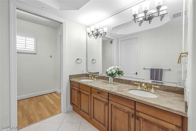 bathroom featuring a chandelier, double vanity, tile patterned flooring, and baseboards