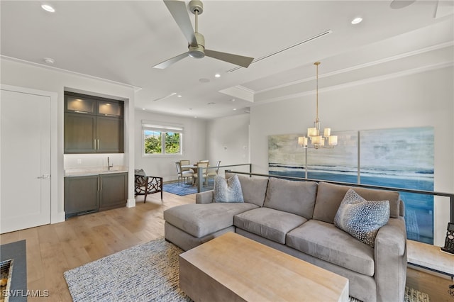 living area featuring light wood-style flooring, ceiling fan, crown molding, a chandelier, and bar