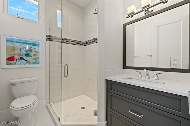 bathroom featuring a shower stall, toilet, vanity, and baseboards