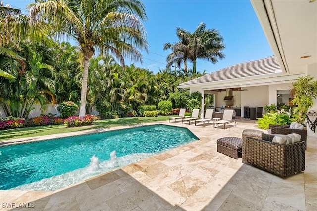 outdoor pool with a patio, an outdoor kitchen, and a ceiling fan