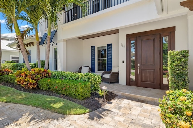 entrance to property featuring stucco siding and covered porch