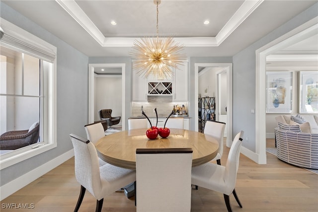 dining space featuring a tray ceiling, a chandelier, baseboards, light wood-type flooring, and recessed lighting